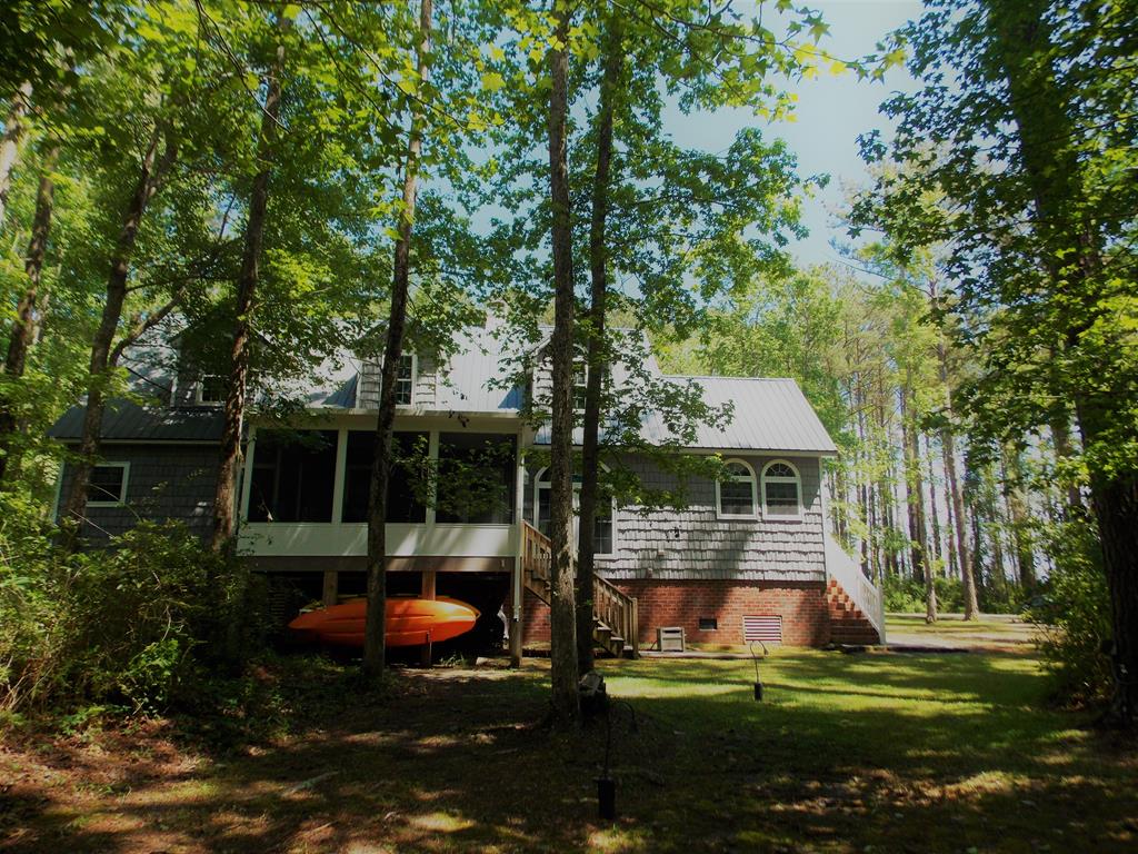 Back of home showing kayaks and screend porch